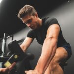 A man is riding an exercise bike in a gym